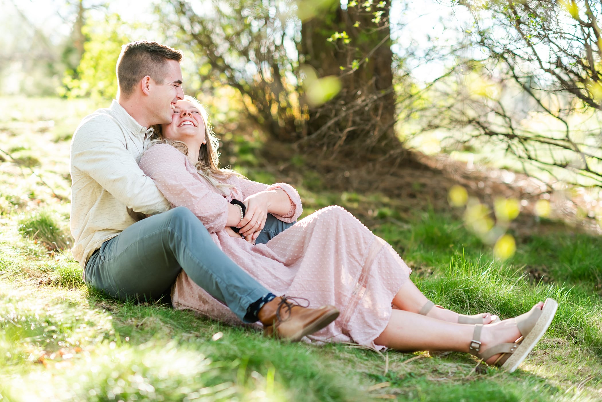 Sitting down engagement photo with laughter from couple in Boise, Idaho