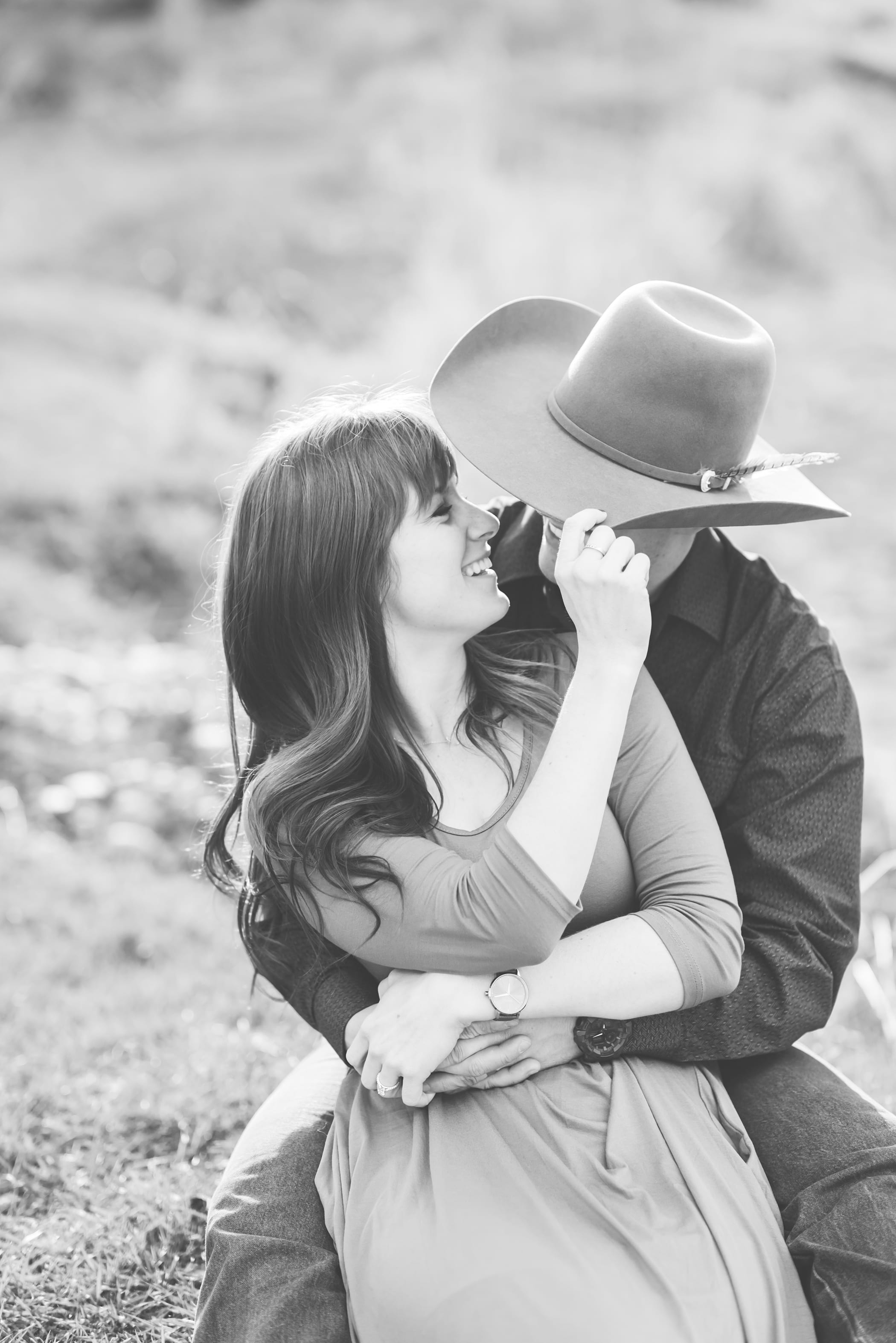 Rustic and country engagement session with cowboy hat and open fieldV