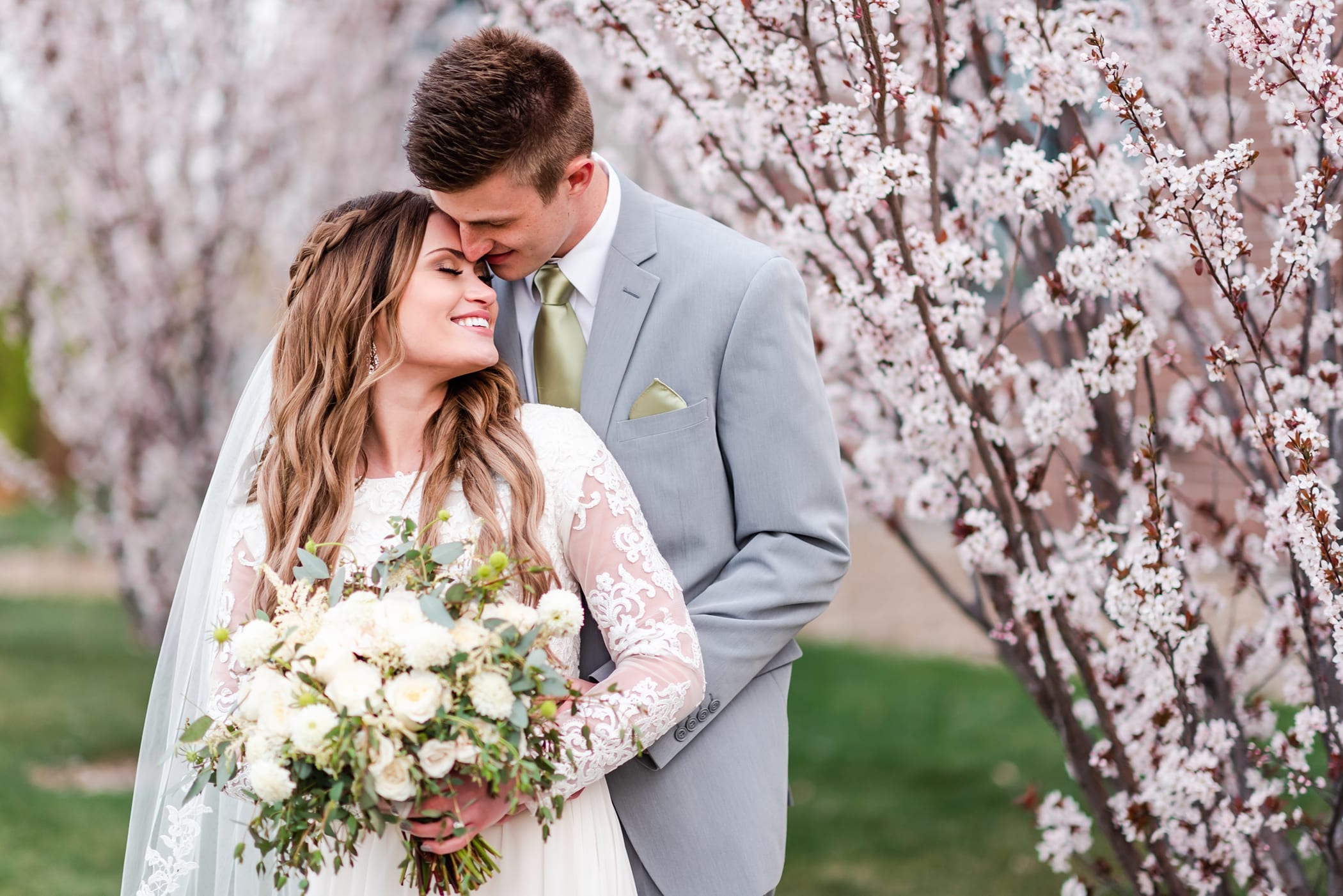 Spring blossom tree wedding photos with white organic bouquet