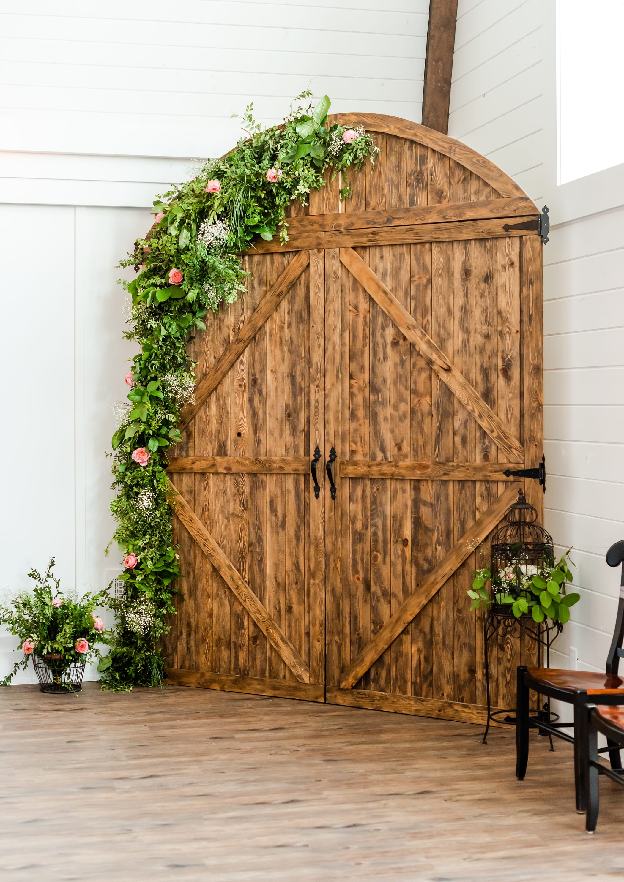 Wood door wedding backdrop with fresh flowers and greenery